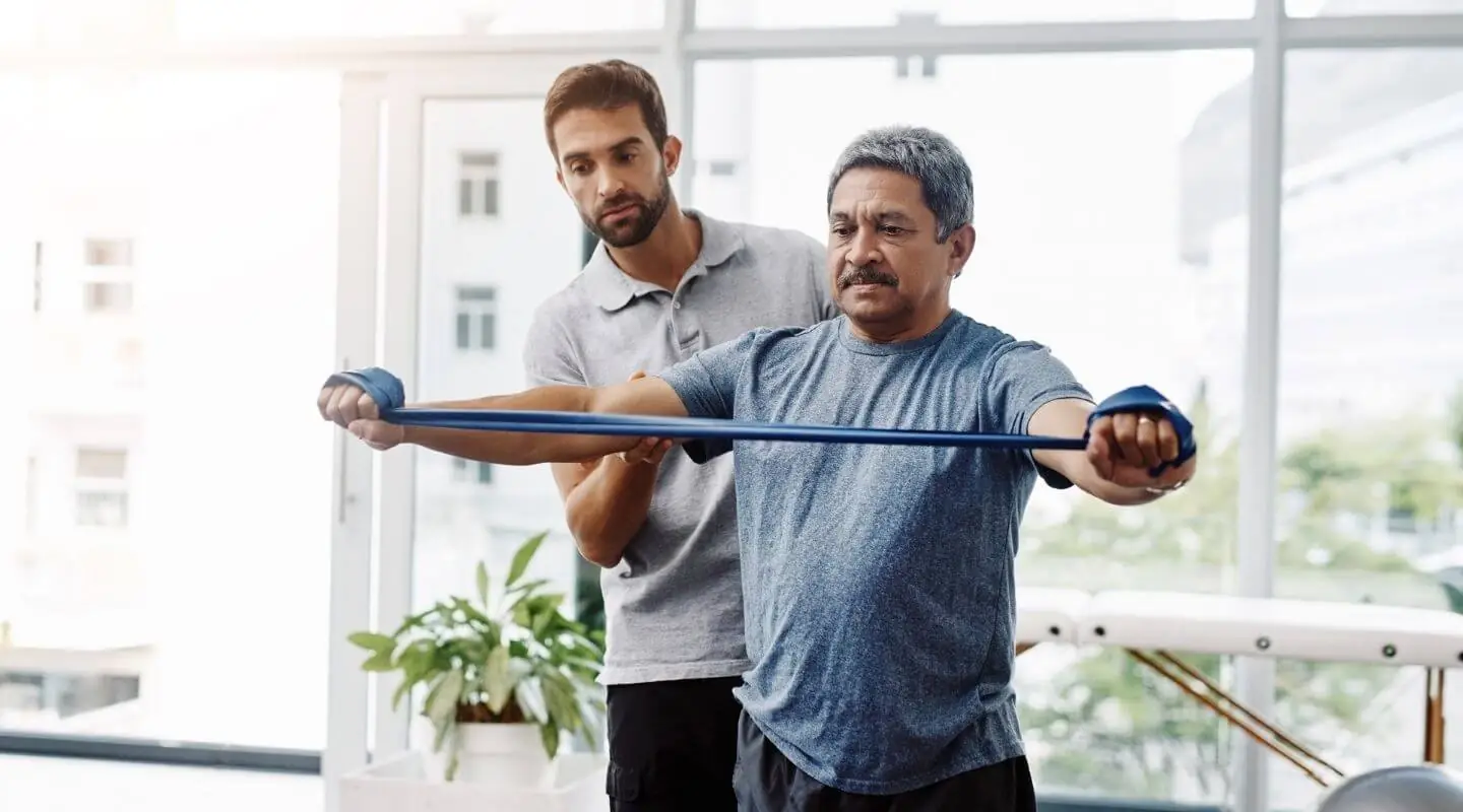 Physical Therapist with male patient using arm band Physical Therapist with male patient using arm band